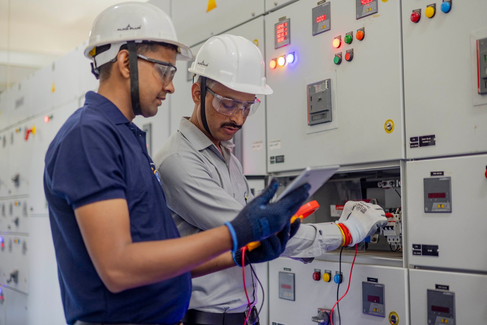 Facility Management students performing practical work on electrical control systems and technical infrastructure equipment.